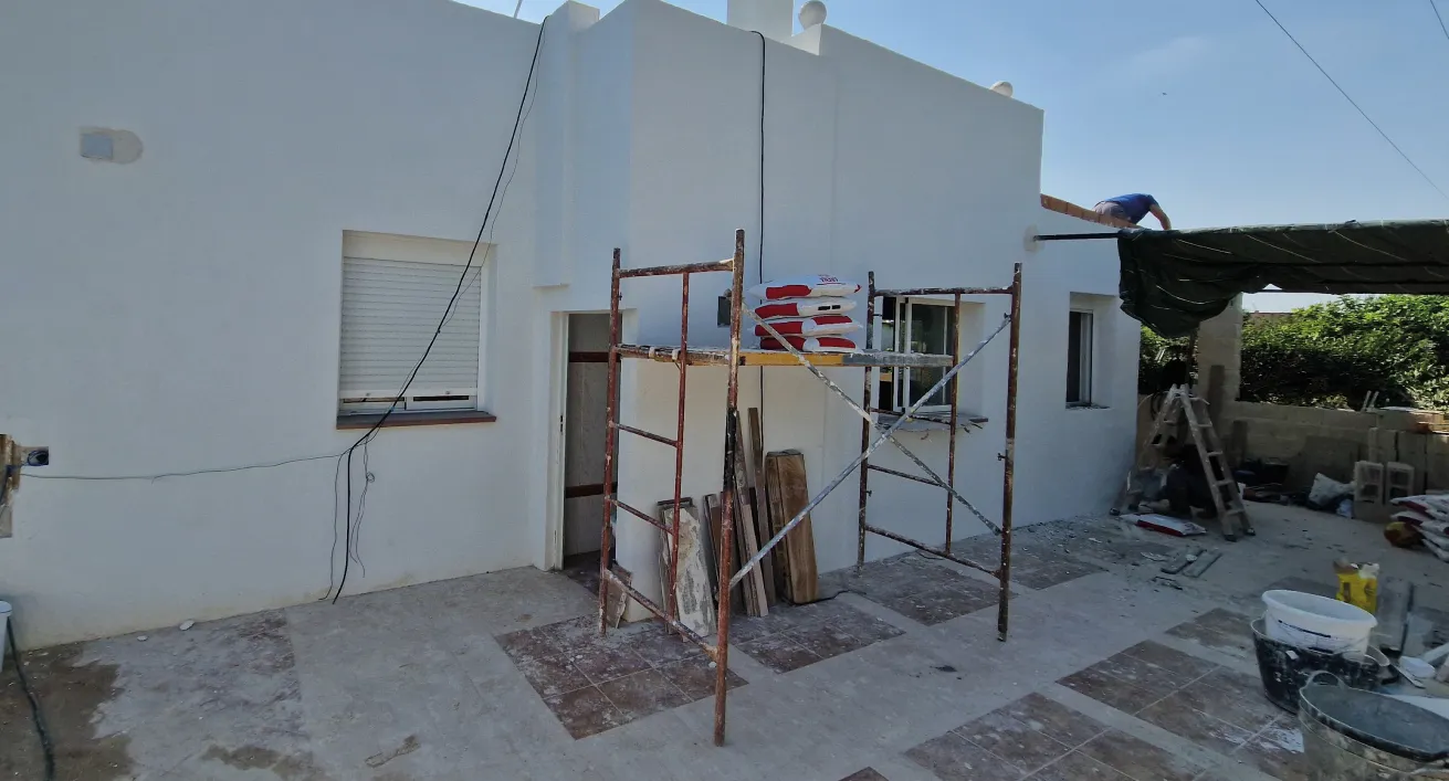 Vivienda en obras de rehabilitación con andamios en el patio